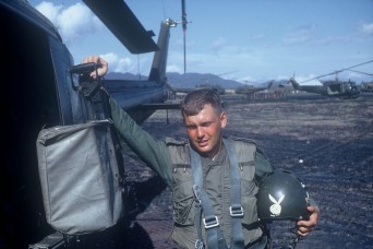 Spc. Roland Scheck, a gunner with the 176th Aviation Company, poses next to a Huey helicopter in Vietnam, 1967. Scheck served with then-Maj. Charles Kettles and lost his leg during a dangerous rescue mission, May 15, and credits Kettles with saving his life.