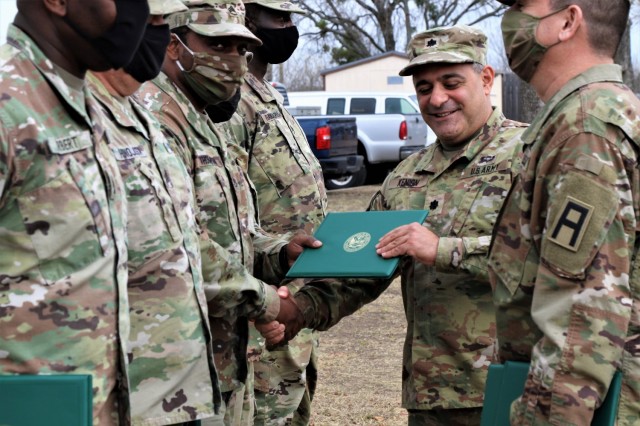 U.S. Army Lt. Col. Benjamin Kenion, commander 3-312th Training Support Battalion, Fort Meade, Maryland, and Command Sgt. Maj. Michael Lopez, senior enlisted advisor for the Battalion, congratulates Soldiers part of the battalion command staff during an awards ceremony for recognition of their hard work and dedication during the mobilization process and achieving mission readiness December 18 at Fort Hood, Texas. The unit is on a yearlong assignment to Fort Hood in support of operations for First Army Division West, 120th Infantry Brigade. (U.S. Army Reserve Photo Staff Sgt. Erick Yates)