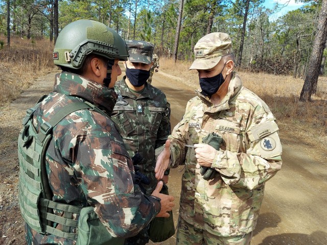 Maj. Gen. Daniel R. Walrath, right, U.S. Army South commanding general, greets a Brazilian Army soldier taking part in the bilateral training exercise at the Joint Readiness Training Center at Fort Polk, Louisiana, Feb. 2, as Lt. Gen. Marcos de Sá Affonso da Costa, chief of training, Land Forces Training Command, Exército Brasileiro, looks on.