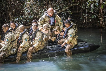 A soldier jumps out of a boat during competitive tactical events at Schofield Barracks, Hawaii, April 8, 2021. The three-day series of events were designed to build cohesive teams.