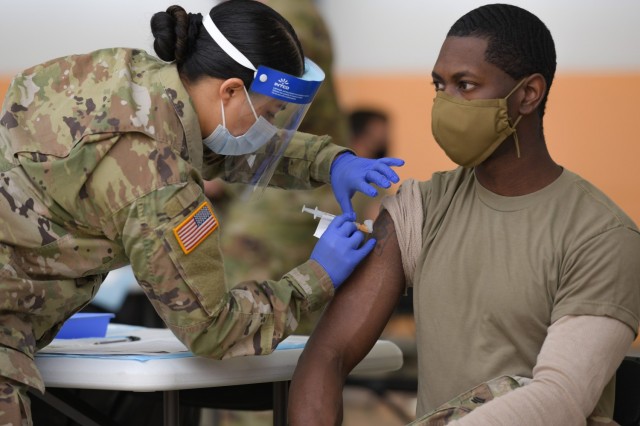 U.S. Army Spc. Eyza Carrasco, left, with 2nd Cavalry Regiment, administers a COVID-19 vaccination at the 7th Army Training Command&#39;s (7ATC) Rose Barracks, Vilseck, Germany, May 3, 2021. The U.S. Army Health Clinics at Grafenwoehr and Vilseck conducted a &#34;One Community&#34; COVID-19 vaccine drive May 3-7 to provide thousands of appointments to the 7ATC community of Soldiers, spouses, Department of the Army civilians, veterans and local nationals employed by the U.S. Army.