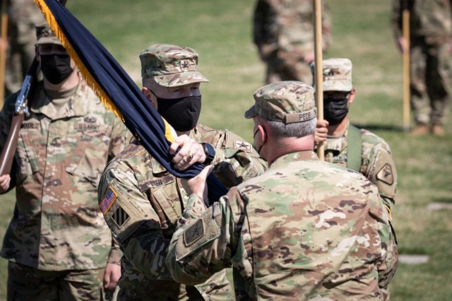 Brig. Gen. William Dyer III, center left, signifies his assumption of command by receiving the colors of the United States Army Reserve Legal Command from Lt. Gen Charles Pede, the Judge Advocate General of the United States Army, during a ceremony held Friday, March 26.
