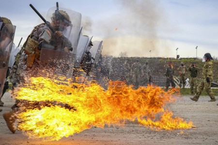 Iowa Army National Guardsmen run through a spray of gasoline and flames during fire phobia training at Camp Novo Selo, Kosovo, April 13, 2021.
