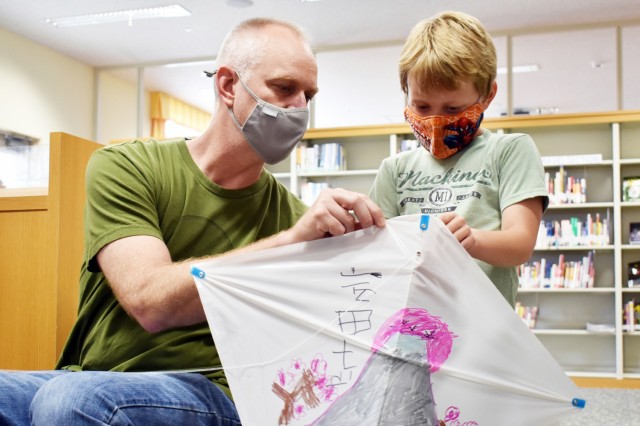 Kevin Boyer, left, helps his son Anders, 7, make a kite during a “Fun Friday” event at the Sagamihara Family Housing Area Library, SFHA, Japan, May 28.