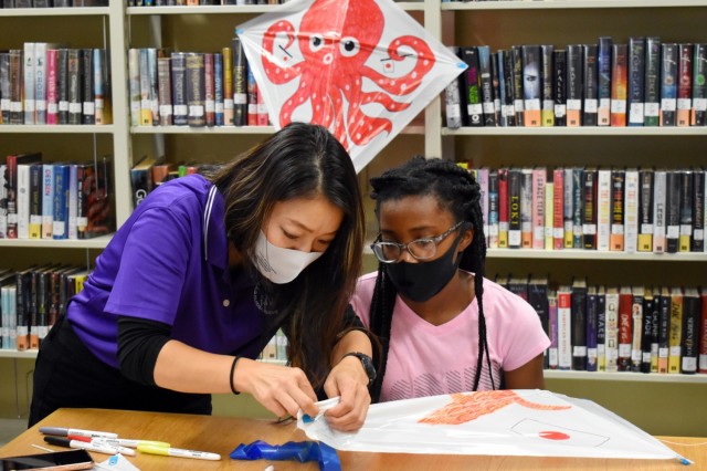 Sari Sugai, left, Camp Zama Army Community Service Exceptional Family Member Program and New Parent Support Program coordinator, helps Alyssa Turner, 12, make a kite during a “Fun Friday” event at the Sagamihara Family Housing Area Library, SFHA, Japan, May 28.