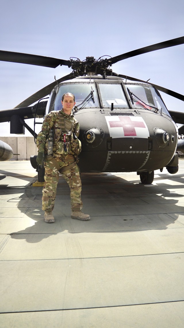 Staff Sgt. Brianna Pritchard, an Army National Guard UH-60 Black Hawk helicopter mechanic from Anchorage, Alaska, poses for a photo in front of a Task Force Phoenix UH-60 Black Hawk MEDEVAC helicopter as Al Asad Air Base, Iraq.