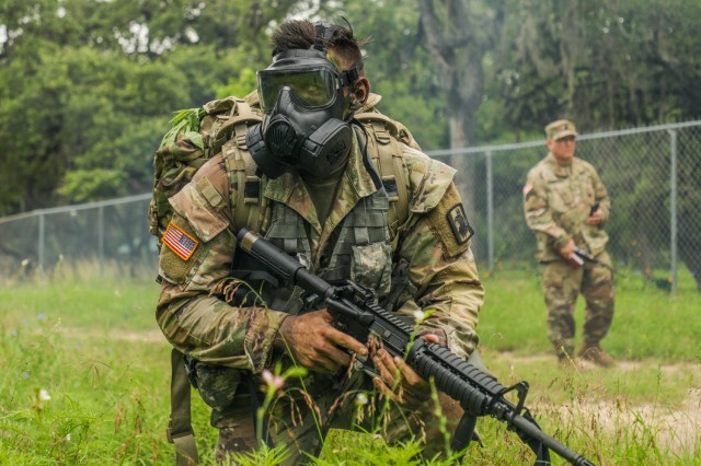U.S. Army Spc. Justin Earnhart, 470th Military Intelligence Brigade, pulls security while wearing a joint service general purpose mask during an exercise in the Army Futures Command Best Warrior Competition on Fort Sam Houston, Texas, June 9 2021. The Best Warrior Competition evaluates a Soldier’s physical ability, tactical performance and knowledge of Army regulations. (U.S. Army photo by Pfc. Joshua Taeckens) (This photo was edited from its original version)