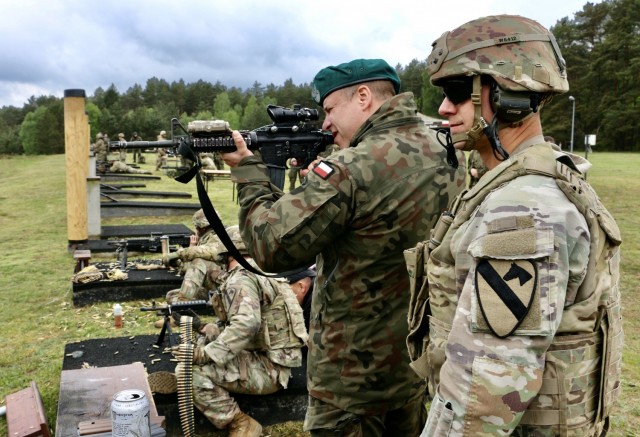 Sgt. 1st Class Christopher Wine, assigned to 1st Squadron, 7th U.S. Cavalry Regiment, acts as range safety NCO while a Polish soldier fires an M4 during a marksmanship competition at Forward Operating Site Drawkso Pomorskie Training Area, Poland, May 27, 2021. 