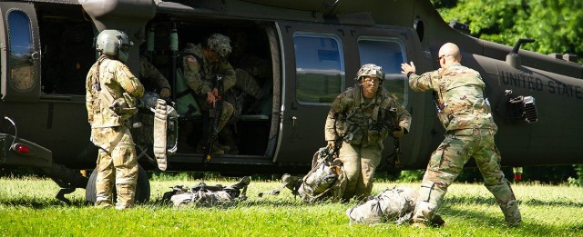 Capt. Curt Lane (Right, standing) directed Class of 2024 cadets as they exit the helicopter at Landing Zone OWL and get in defensive positions on the last day of the field training exercise June 23 at Camp Buckner.