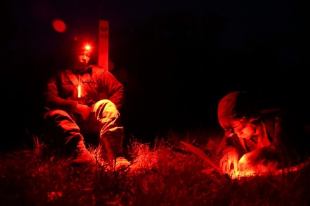 1st Lt. Ryan Harakel, an Army Reserve Medical Service Officer from Des Moines, Iowa, is tested on night land navigation skills while Spc. Heather Fitzwater, a Reserve dental technician from Lubbock, Texas observes, during an Expert Field Medical Badge event held May 16-22, 2021 at Fort McCoy, Wisconsin. This EFMB event is the first hosted by the Army Reserve, and offers an opportunity for Soldiers in the medical field to earn the special skill award by demonstrating exceptional competence and outstanding performance in Soldier and medical tasks. Less than twenty percent of candidates pass the challenging test.