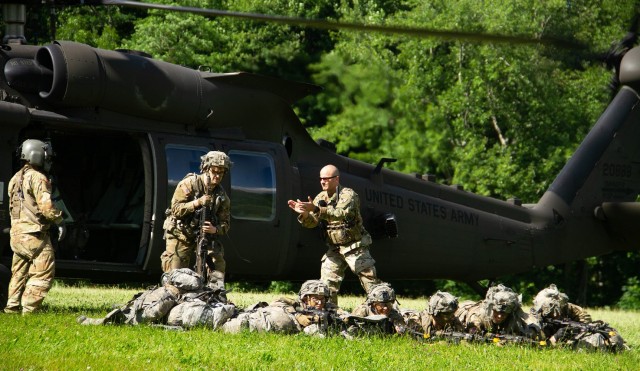 Capt. Curt Lane (Right, standing) directed Class of 2024 cadets as they exit the helicopter at Landing Zone OWL and get in defensive positions on the last day of the field training exercise June 23 at Camp Buckner.