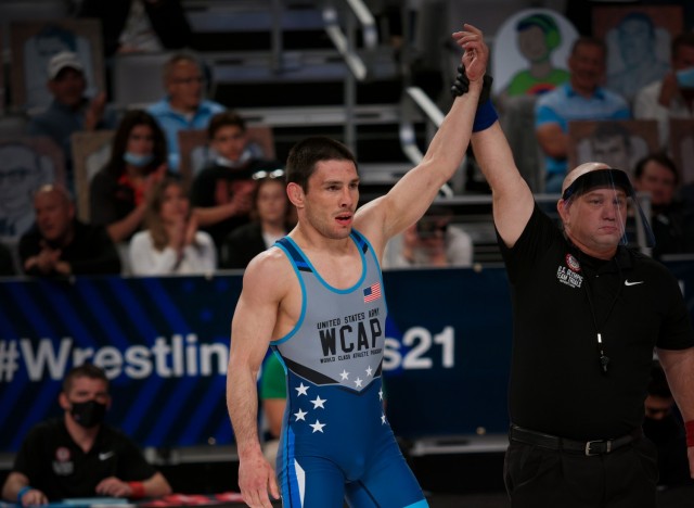 A referee raises Sgt. Ildar Hafizov&#39;s hand in victory after he defeated Sgt. Ryan Mango to qualify for the Summer Olympics in Tokyo in April 2021. 