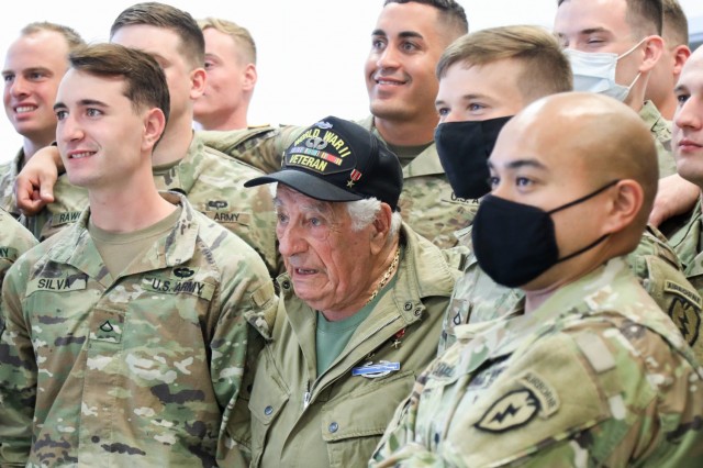 Vincent Speranza, World War II Veteran and machine gunner from the 501st Infantry Regiment, takes a group photo with junior paratroopers of the 1st Battalion, 501st Infantry Regiment, during a visit to Joint Base Elmendorf-Richardson, July 15, 2021. Speranza traveled to JBER to meet and share stories about his World War II experiences with the paratroopers of the 1-501st PIR and the 4th Infantry Brigade Combat Team (Airborne), 25th Infantry Division, “Spartan Brigade.” The Spartan Brigade is the only airborne infantry brigade combat team in the Arctic and Pacific theaters, providing the combatant commander with the unique capability to project an expeditionary force by air.