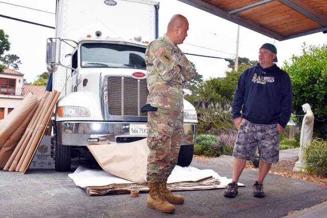 Col. Varman Chhoeung, commander of U.S. Army Garrison Presidio of Monterey, speaks with Zane Whetstone, who is moving to Japan with his family, as movers pack up his household goods in Pebble Beach, Calif., July 16. Chhoeung accompanied a quality assurance inspector with the Presidio of Monterey Transportation Office to speak with service members and their families and ensure their permanent-change-of-station moves are going well.