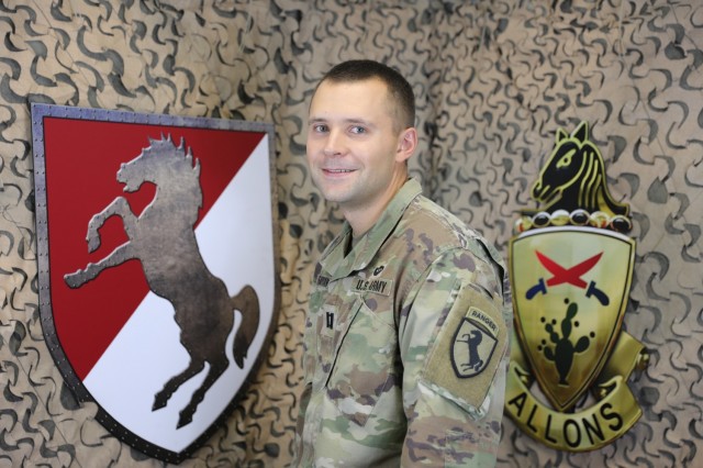 Chaplain (Capt.) Aaron Fabian, Chaplain for 1st Squadron, 11th Armored Cavalry Regiment poses with the Ironhorse shield and 11th Armored Cavalry Regiment distinctive unit insignia in the Regimental Public Affairs Office, Fort Irwin, Calif on July 16th, 2021.  (U.S. Army photo by Pvt. James Newsome)