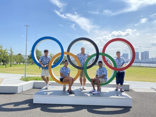 From left: Gaku Hashimoto, Marshallese delegation member; Colleen Furgeson, athlete; Johnathan Jordan, swim coach; Phillip Kinono, athlete; and Amy LaCost, chef de mission, visit an Olympic rings installation inside the Olympic Village near Tokyo’s Rainbow Bridge in July 2021. Furgeson and Kinono represent the Republic of the Marshall Islands in this year’s Summer Games.