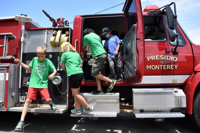 Cub Scouts exit a Presidio of Monterey Fire Department fire truck during the Monterey Cub Scout Camp at the Presidio of Monterey, Calif., July 29.