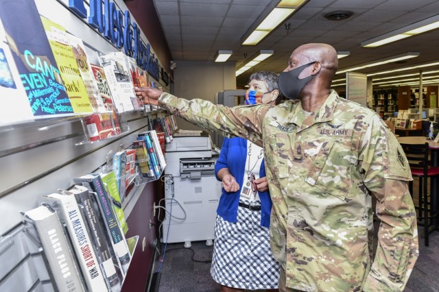 Master Sergeant Osae Bekoe with the U.S. Army Medical Test and Evaluation Activity (USAMTEAC) reviews the featured titles at the MEDCoE Stimson Library with the assistance of Library Director Jodi Quesnell.