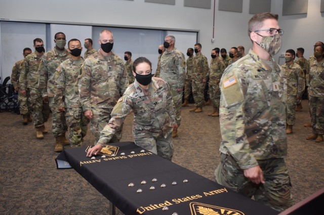 Chaplain Basic Officer Leader Course 21-002 student, Chap. (Capt.) Kelsey Underwood files by to pick up a regimental pin during the Chaplain Corps Regimental Pinning Ceremony at the Chaplain School campus on Fort Jackson Aug. 6.