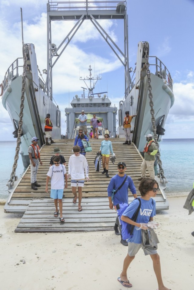 Personnel and students from U.S. Army Garrison-Kwajalein Atoll disembark from the USAV Great Bridge for the 2021 Child and Youth Services Commander's Summer Challenge beach clean-up on Bigej Aug. 1, 2021.
