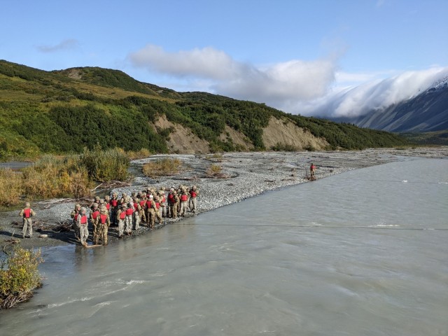 Students in the Basic Military Mountaineering Course wait their turn to cross the swiftly flowing, 38-degree water of Phelan Creek on August 18. The 15-day course takes place at the Black Rapids Training Site of the Northern Warfare Training Center in central Alaska. (Photo by Eve Baker, Fort Wainwright Public Affairs Office)