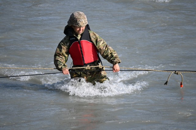 2nd Lt. Joy Kim crosses Phelan Creek in central Alaska on August 18 during the Basic Military Mountaineering Course conducted at the Black Rapids Training Site of the Northern Warfare Training Center. The source of the creek is Gulkana Glacier, and the water temperature was approximately 38 degrees Fahrenheit. The river crossing was the final event of the 15-day course. (Photo by Eve Baker, Fort Wainwright Public Affairs Office)