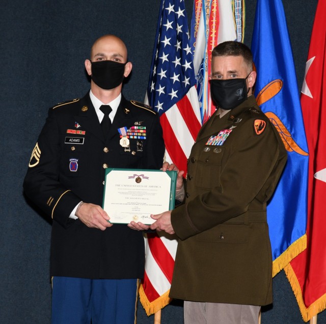 U.S. Army Staff Sgt. Travis M. Adams, who serves as a flight medic with Fort Rucker's air ambulance detachment, receives the Soldier's Medal from Maj. Gen. David J. Francis, U.S. Army Aviation Center of Excellence and Fort Rucker commander, for his courageous actions in responding to a multivehicle accident in the local community during a ceremony at the U.S. Army Aviation Museum Aug. 27, 2021. (U.S. Army photo by Kelly Morris)