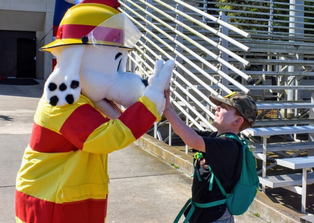 Ian Bolton, 5, gives Sparky the Fire Dog a high five during the Volksmarch at the Presidio of Monterey, Calif., Aug. 28.
