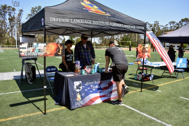 Janice Quenga, left, U.S. Army Garrison Presidio of Monterey antiterrorism officer, and Glen Harrison, Defense Language Institute Foreign Language antiterrorism officer, staff a table during the Volksmarch at the Presidio of Monterey, Calif., Aug. 28.