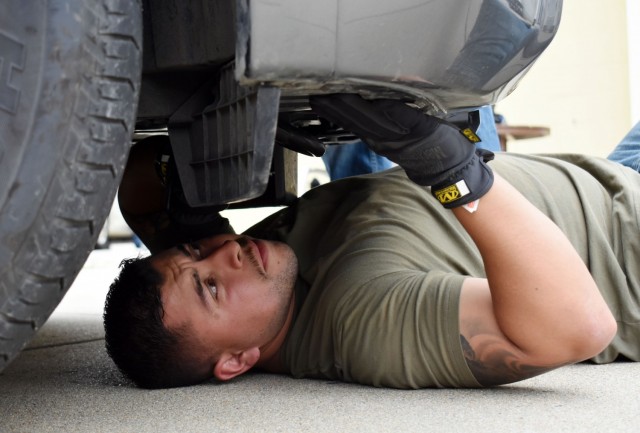 Lt. Jesus Sanchez, a Presidio of Monterey security guard, searches under a vehicle for hidden contraband during vehicle interdiction training at the Stilwell Community Center, Ord Military Community, July 13.