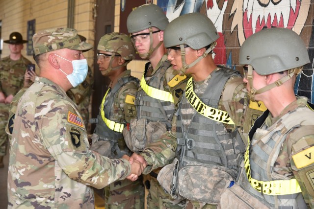 Lt. Col. Dennis Segui, Commander 187th Medical Battalion, shakes hands with Pfc Jaden King after presenting him with a commander’s coin.