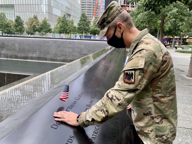 Army Gen. Daniel Hokanson, chief, National Guard Bureau, places a flag and pauses Sept. 8, 2021, to remember U.S. Military Academy classmate Douglas Gurian, among the almost 3,000 names engraved in the 9/11 Memorial. “It was an attack on our nation, and deeply personal to so many of us,” Hokanson said. The National Guard transformed from a strategic reserve to an operational force after the Sept. 11, 2001, attacks. This image was acquired using a cellular device. (U.S. Army National Guard photo Master Sgt. Jim Greenhill).