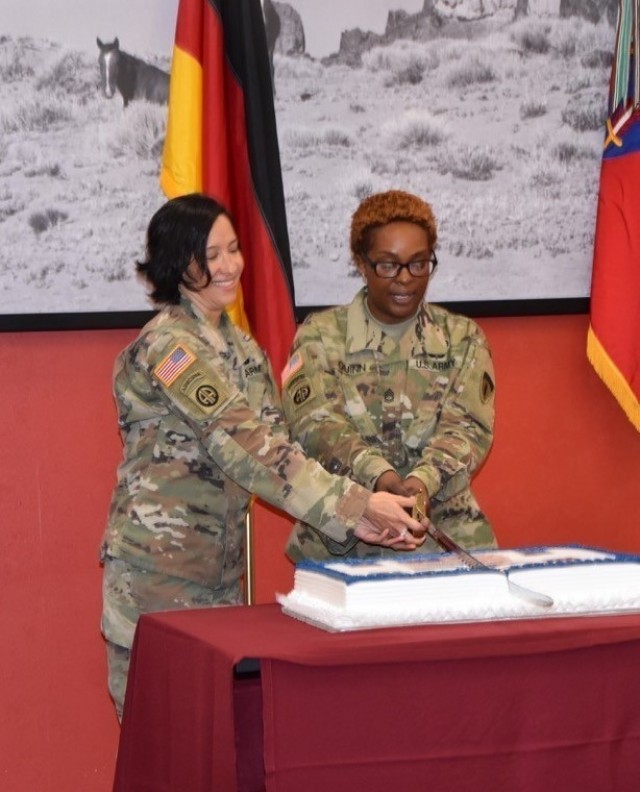 Lt. Col. Claudia Pena with G5, U.S. Army Europe-Africa and Sgt. 1st Class Joycelyn Quinn, USAREUR-AF Equal Opportunity Advisor, cuts the Women’s Equality Day cake during the ceremony at the dining facility on Clay Kaserne.