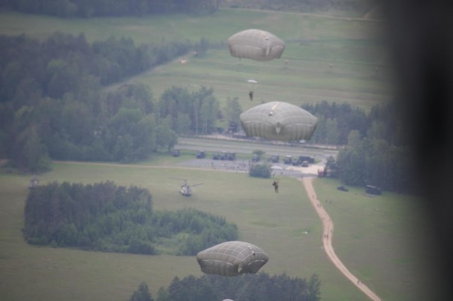 Soldiers with 1st Squadron, 91st Cavalry Regiment, 173rd Infantry Brigade Combat Team (Airborne) parachute to the ground at U.S. Army Garrison Grafenwöhr Training Area, Germany. Chief Warrant Officer 2 Erin Allen, a pilot with 2nd General Support Aviation Battalion, 1st Aviation Regiment “Fighting Eagles,” 1st Aviation Combat Brigade, and other pilots were qualifying on static-line operations June 9, 15 and 16, 2021, during their deployment as a rotational force to Europe in support of Atlantic Resolve. Rotational forces conduct rigorous training in realistic training environments with NATO allies and partners to ensure they are ready and lethal. 