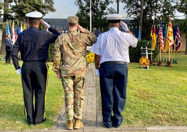 Garrison Police Chief Jason Kesselring, Garrison Command Sgt. Maj. Richard Russell and Garrison Deputy Fire Chief Rodney Millbrooks salute the wreath after placing it during the September 11th remembrance ceremony.