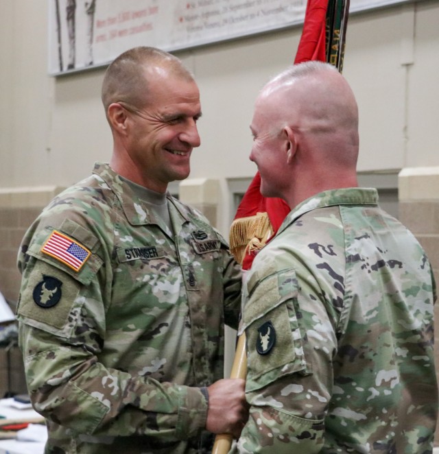 Command Sgt. Maj. Matthew Strasser, the outgoing senior enlisted leader of the 2nd Infantry Brigade Combat Team, 34th Infantry Division, Iowa Army National Guard, passes the unit colors to Col. Derek Adams, the brigade commander, during the change of responsibility ceremony for the 2nd Infantry Brigade Combat Team, 34th Infantry Division, at the Camp Dodge Joint Maneuver Training Center on Sept. 10, 2021. The ceremony was a unique event, as Matthew transferred responsibility to his younger brother, Command Sgt. Maj. Jeremy Strasser. The two brothers have dedicated a combined 47 years of service to the Red Bull brigade. (U.S. Army National Guard photo by Staff Sgt. Tawny Schmit)
