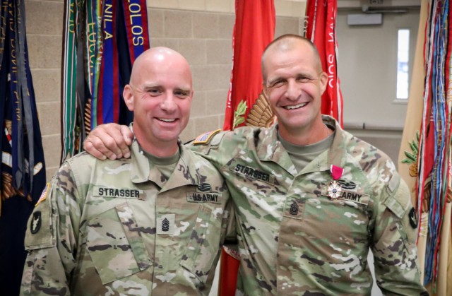 Command Sgt. Maj. Jeremy Strasser and Command Sgt. Maj. Matthew Strasser smile for a photo after the change of responsibility ceremony for the 2nd Infantry Brigade Combat Team, 34th Infantry Division, Iowa Army National Guard, at the Camp Dodge Joint Maneuver Training Center on Sept. 10, 2021. The ceremony was a unique event as Jeremy assumed responsibility from his older brother Matthew. The two brothers have dedicated a combined 47 years of service to the Red Bull brigade and have served on two deployments to together. (U.S. Army National Guard photo by Staff Sgt. Tawny Schmit)
