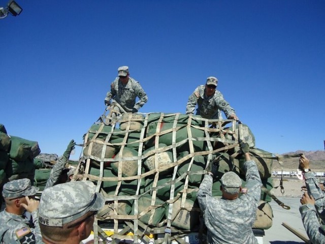 Then Sgt. Maj. Matthew Strasser and then Sgt. 1st Class Jeremy Strasser help load sandbags at Fort Irwin, Calif., before their deployment to Afghanistan in 2010. On Sept. 10, 2021, Matthew passed responsibility of the 2nd Infantry Brigade Combat Team, 34th Infantry Division, Iowa Army National Guard, to his younger brother Jeremy, marking a unique moment in Iowa National Guard history. The two brothers have dedicated a combined 47 years of service to the Red Bull brigade and have served on two deployments together. (U.S. Army National Guard photo by Staff Sgt. Tawny Schmit)