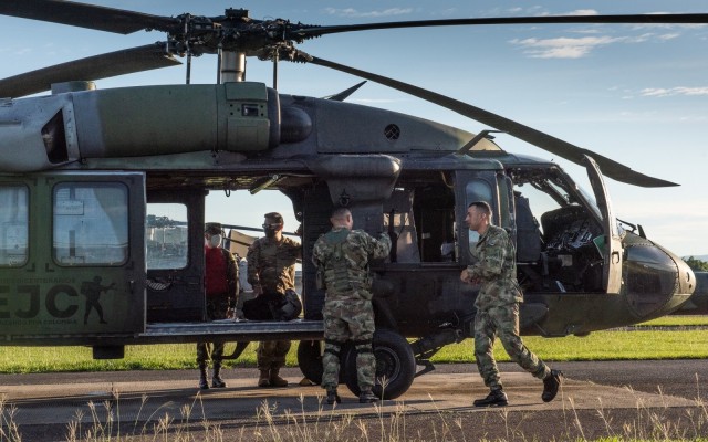 U.S. Army Chief Warrant Officer 3 Mauricio Garcia, left inside Black Hawk door, and his Colombian safety officer counterpart, Capt. Cristian Castiblanco, inspect a refueling operation at Tolemaida Army Base in Colombia. Garcia, a UH-60M Black Hawk pilot and aviation safety officer, is deployed here as part of a technical advising team from U.S. Army Security Assistance Command’s Fort Bragg-based training unit, the Security Assistance Training Management Organization. 