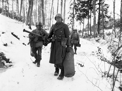 American engineers emerge from the woods and move out of defensive positions after fighting in the vicinity of Bastogne, Belgium.