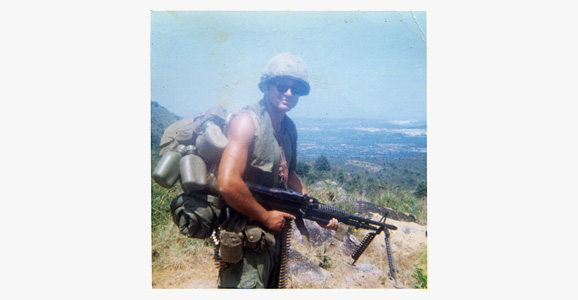 Specialist Leslie Sabo holding a M60 Machine Gun