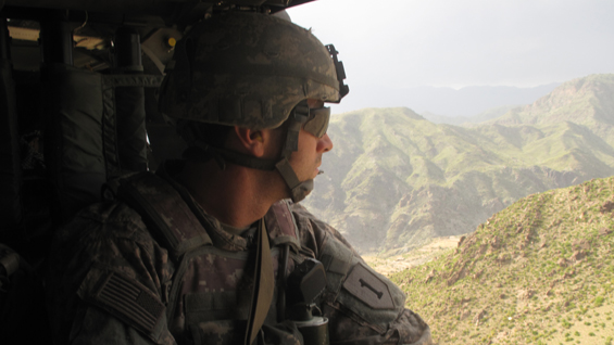 Capt. William Swenson looks out at the rough terrain of Eastern Afghanistan from a Black Hawk helicopter.